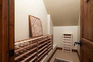 Wine room featuring carpet and vaulted ceiling