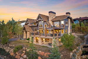 Back house at dusk with a balcony and a patio area