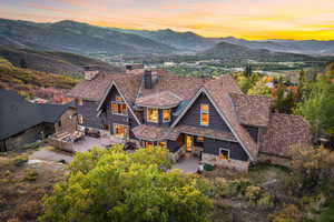 Back house at dusk featuring a deck with mountain view