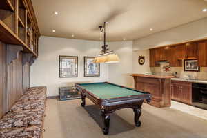 Game room featuring light colored carpet, wet bar, and pool table