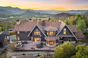 Back house at dusk featuring a deck with mountain view