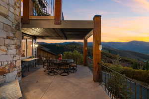 Patio terrace at dusk featuring a pergola and a mountain view