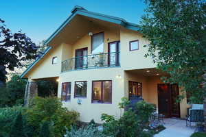 Back of property featuring a balcony and a patio