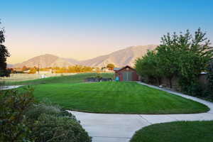 Yard at dusk with a storage unit and a mountain view