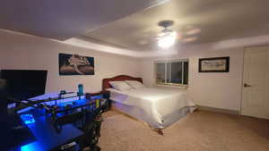 Carpeted bedroom featuring ceiling fan