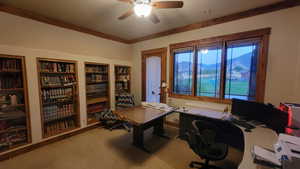 Carpeted office with built in shelves, a mountain view, and ceiling fan