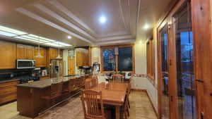 Kitchen featuring pendant lighting, sink, decorative backsplash, stainless steel appliances, and a raised ceiling