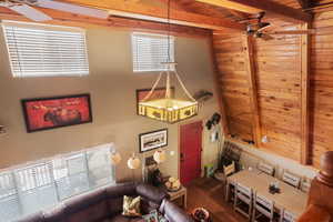 Living room with lofted ceiling with beams, ceiling fan, wooden ceiling, and hardwood / wood-style floors