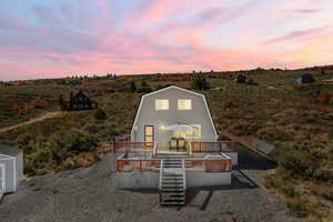 Exterior house at dusk featuring a wooden deck