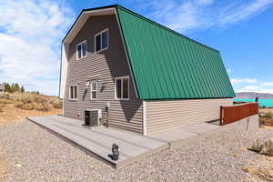 View of home's exterior with a deck with mountain view and central air condition unit