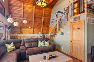 Living room featuring high vaulted ceiling, beam ceiling, wooden ceiling, and hardwood / wood-style floors