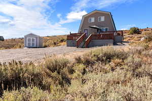 Rear view of house featuring a storage shed and a deck