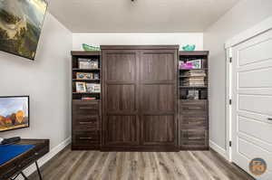 Interior space with a textured ceiling and wood-type flooring