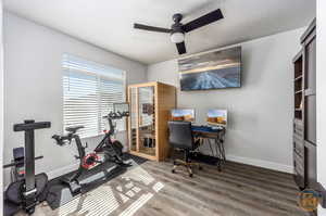 Exercise room with ceiling fan, hardwood / wood-style floors, and a textured ceiling