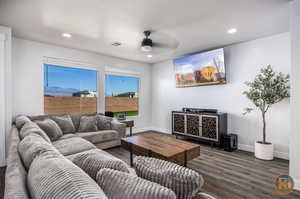 Living room with a textured ceiling, dark hardwood / wood-style floors, and ceiling fan