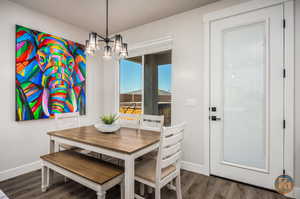 Dining area with dark hardwood / wood-style floors and a chandelier