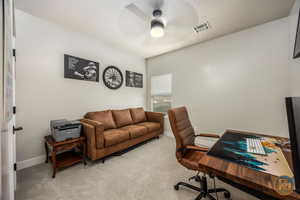 Carpeted office with a textured ceiling and ceiling fan