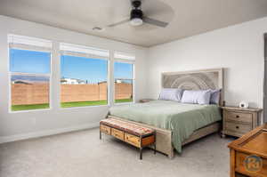 Bedroom with ceiling fan and light carpet