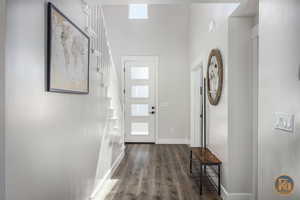 Foyer with dark hardwood / wood-style floors and a healthy amount of sunlight