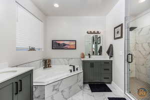 Bathroom featuring independent shower and bath and vanity