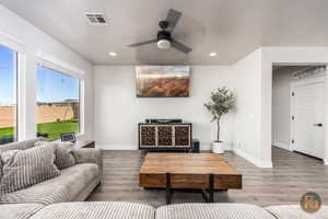 Living room featuring ceiling fan, a textured ceiling, and hardwood / wood-style floors