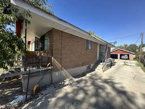 View of side of property with an outdoor structure and a garage