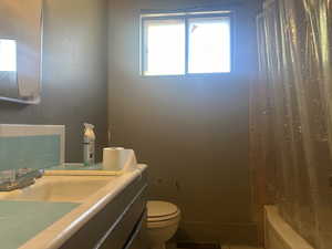 Full bathroom #1 featuring vanity, toilet, tasteful backsplash, and shower / bath combo