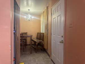 Hallway with an inviting chandelier