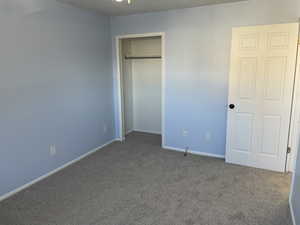 Unfurnished bedroom featuring a closet and carpet flooring