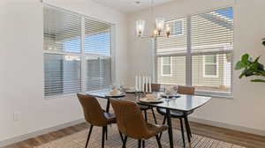 Dining space with wood-type flooring and an inviting chandelier