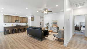 Living room with ceiling fan and light hardwood / wood-style flooring