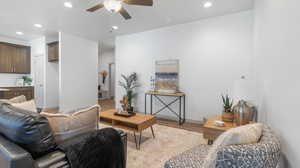 Living room with light hardwood / wood-style flooring and ceiling fan