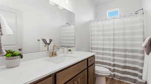 Bathroom with a shower with shower curtain, vanity, toilet, and hardwood / wood-style flooring