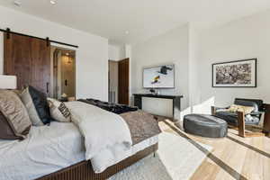 Bedroom featuring a barn door and light wood-type flooring