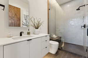 Bathroom featuring vanity, toilet, and walk in shower