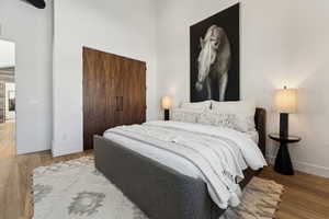 Bedroom with hardwood / wood-style floors and a closet