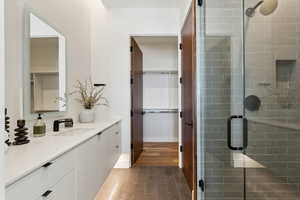 Bathroom featuring vanity, a shower with door, and hardwood / wood-style floors