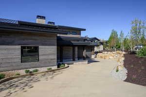 View of front of house featuring a standing seam roof, a chimney, and metal roof