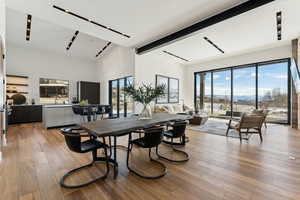 Dining area with beam ceiling and light hardwood / wood-style floors