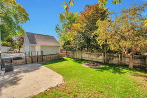 View of yard featuring a patio, an outdoor structure, and a garage