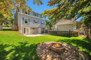 Back of property featuring cooling unit, a yard, a patio area, and a fire pit