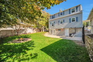 Rear view of property featuring cooling unit, a lawn, and a patio