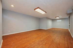 Spare room with a textured ceiling and hardwood / wood-style floors