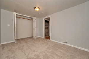 Unfurnished bedroom featuring a closet and carpet flooring