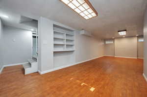 Basement with wood-type flooring and a textured ceiling