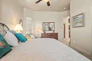 Carpeted bedroom featuring ceiling fan