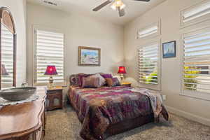 Bedroom with ceiling fan and light carpet