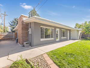 Rear view of house featuring a lawn, a patio, and central AC