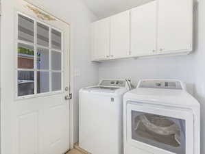 Washroom with cabinets and included washer and dryer