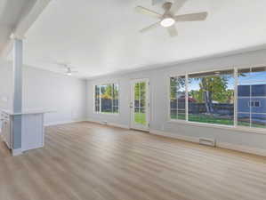 Unfurnished living room featuring ceiling fan and light hardwood / wood-style flooring